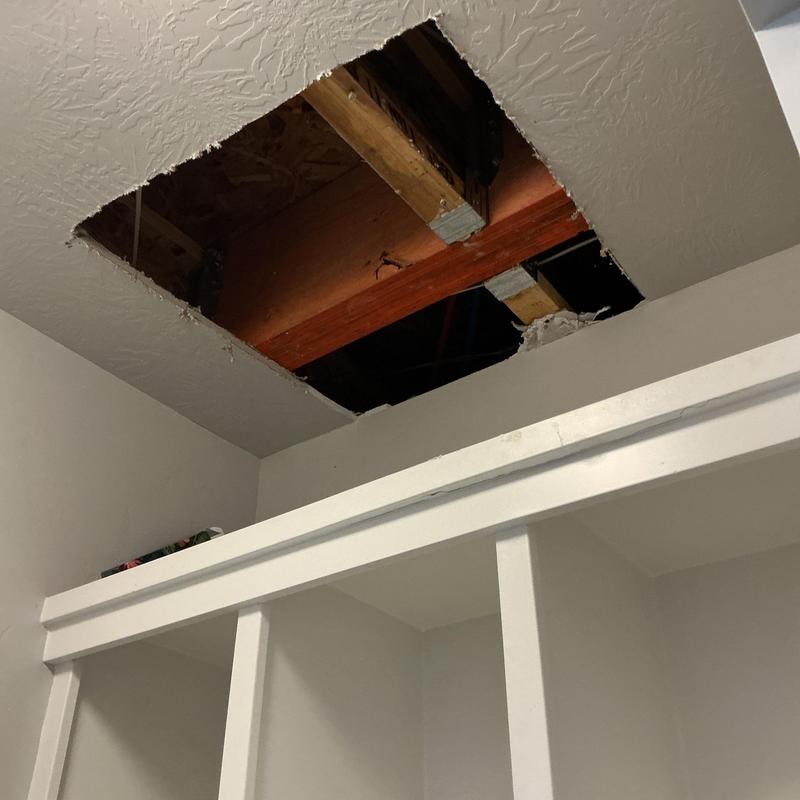 Ceiling access hole revealing wooden beams above Ceiling access hole revealing wooden beams above