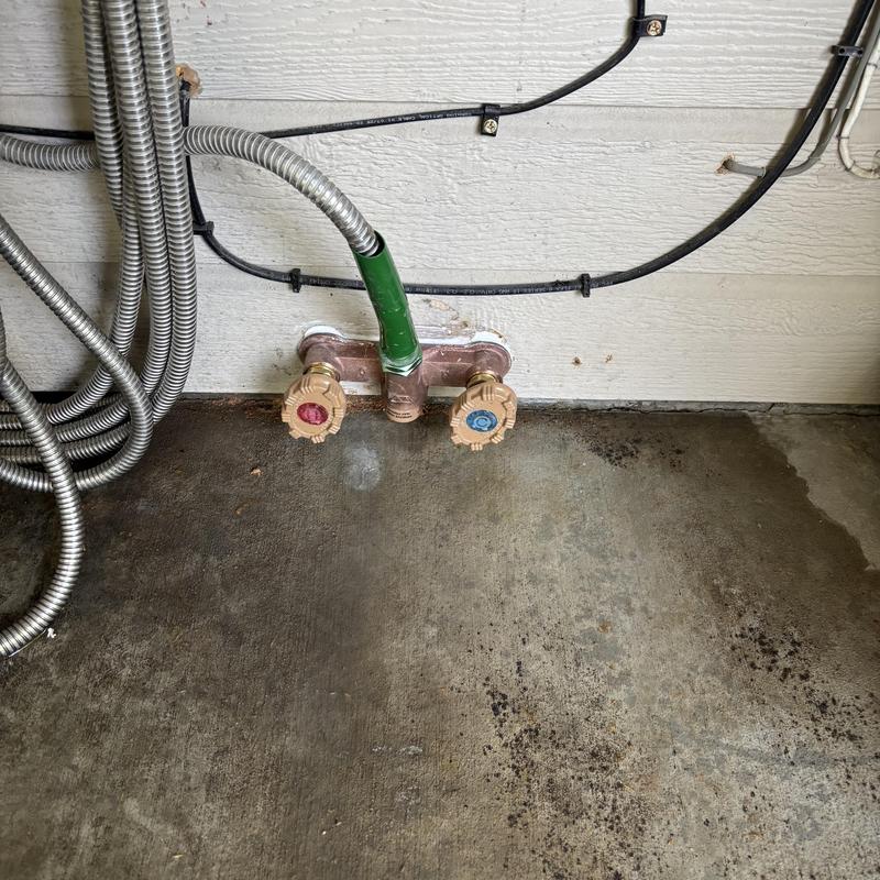 Hot and cold hose bib with shutoff valves on patio wall Hot and cold hose bib with shutoff valves on patio wall