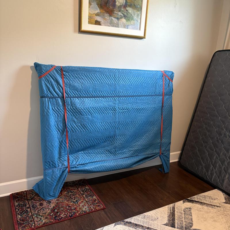Headboard wrapped in moving blanket for transport