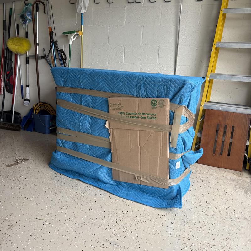 Couch wrapped in padding and tape for moving