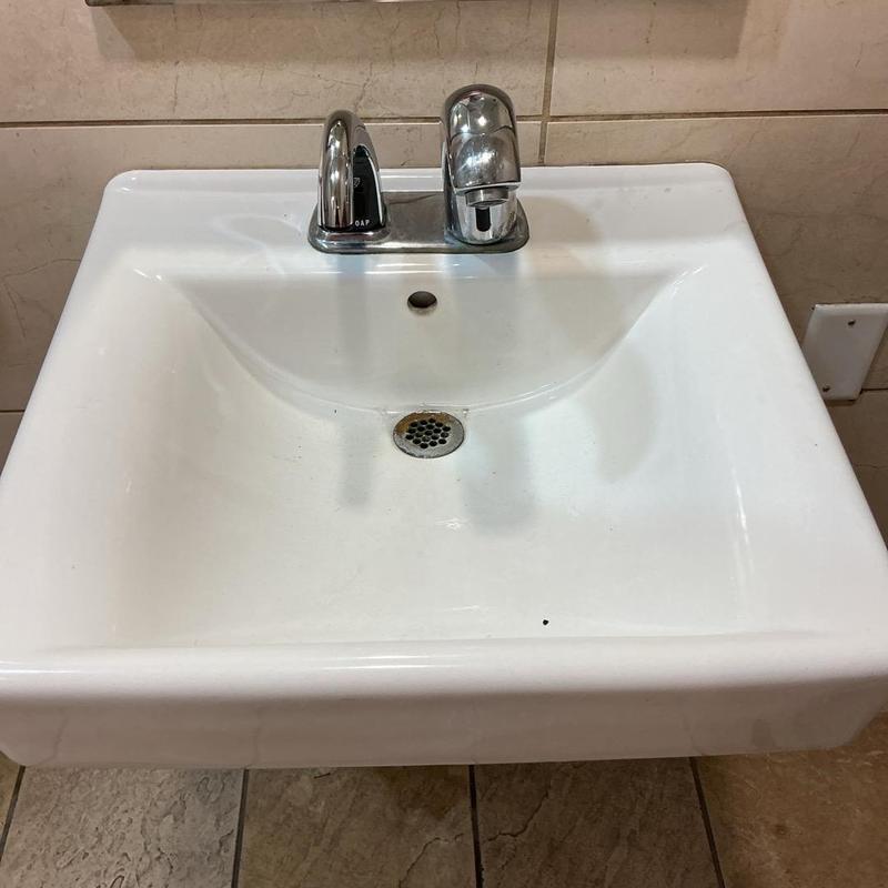 Sensor faucet with replaced batteries in men's bathroom Sensor faucet with replaced batteries in men's bathroom