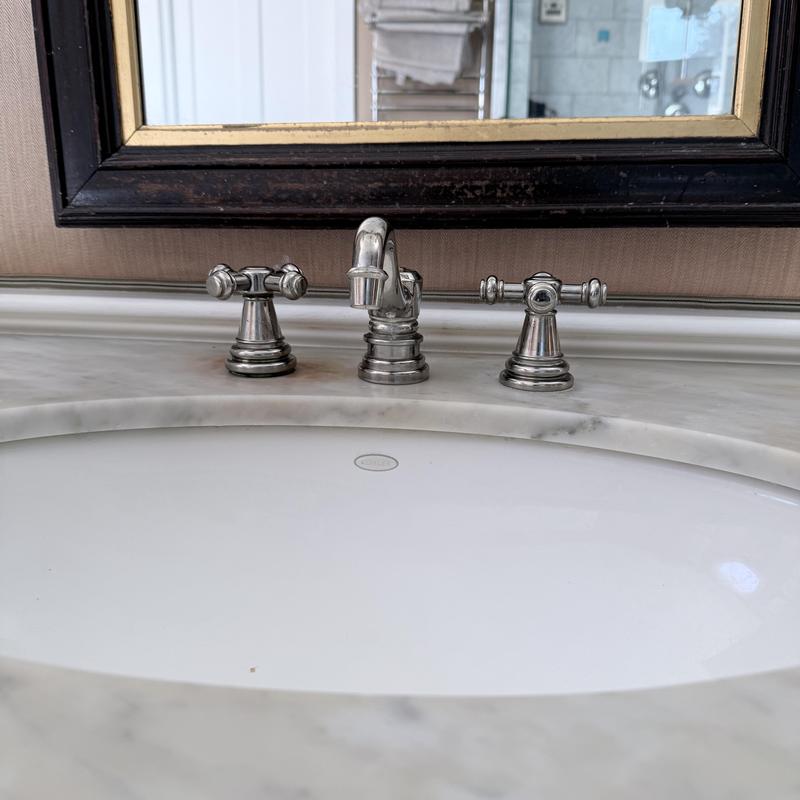 Bathroom sink faucet with chrome handles on marble countertop Bathroom sink faucet with chrome handles on marble countertop