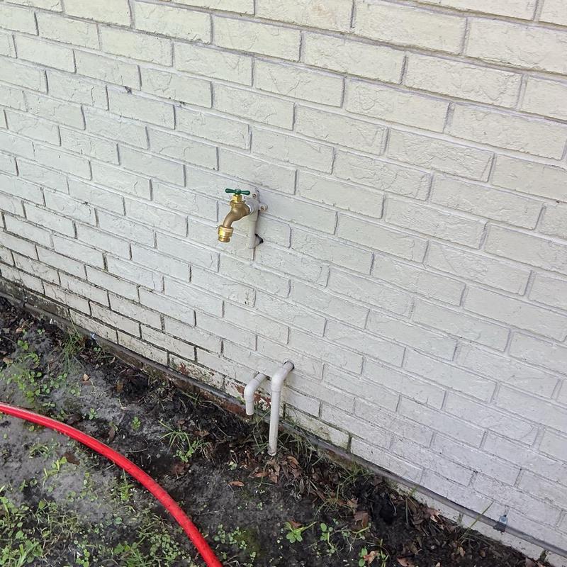 Hose bibb and exterior water pipes on brick wall Hose bibb and exterior water pipes on brick wall