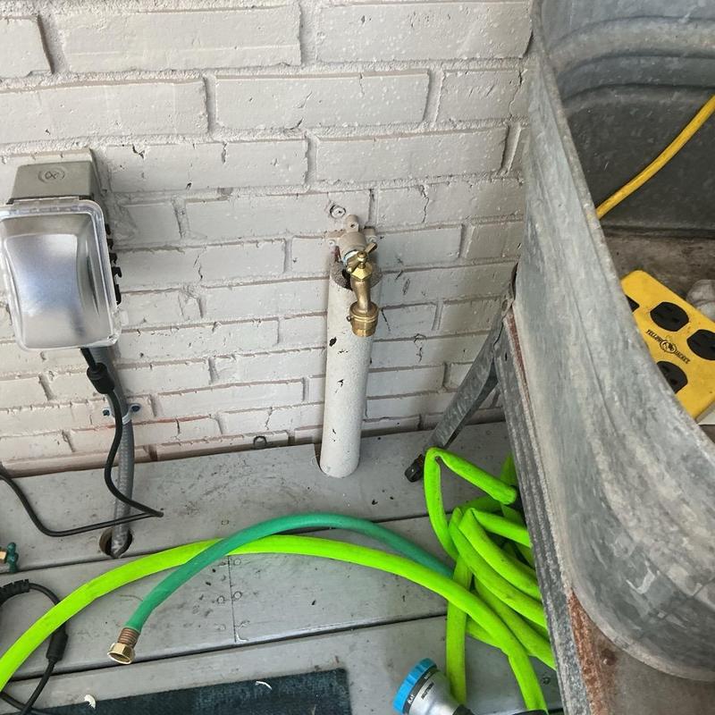 Hose bibb with garden hose on concrete deck Hose bibb with garden hose on concrete deck
