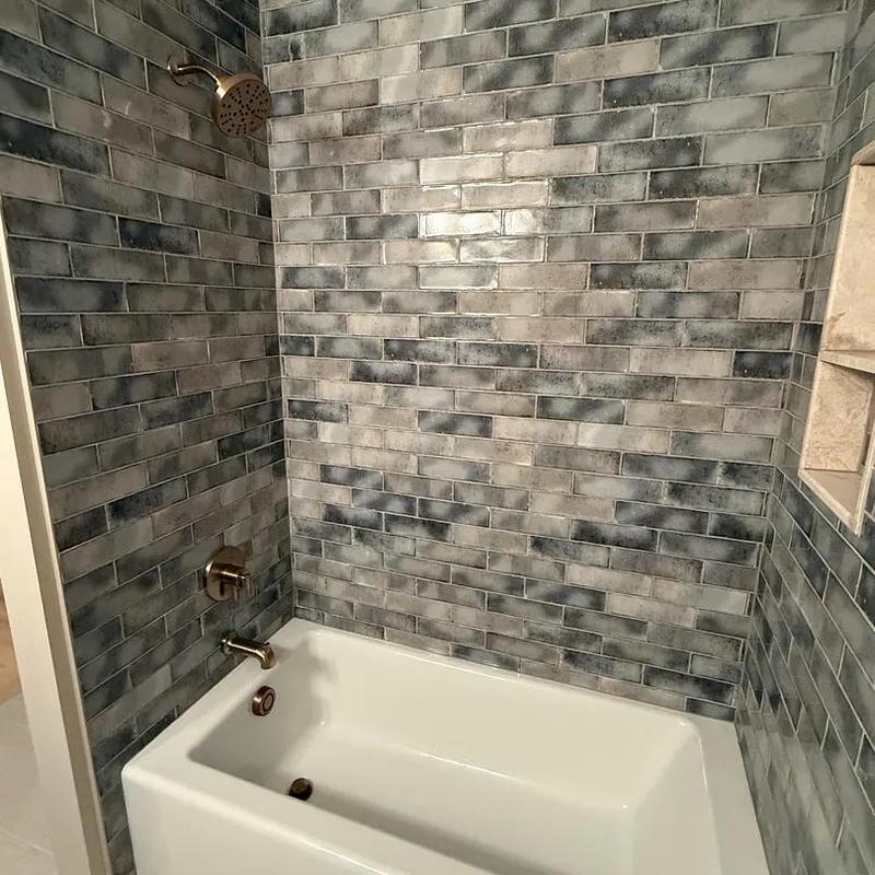 Shower and tub fixtures with gray tile walls Shower and tub fixtures with gray tile walls