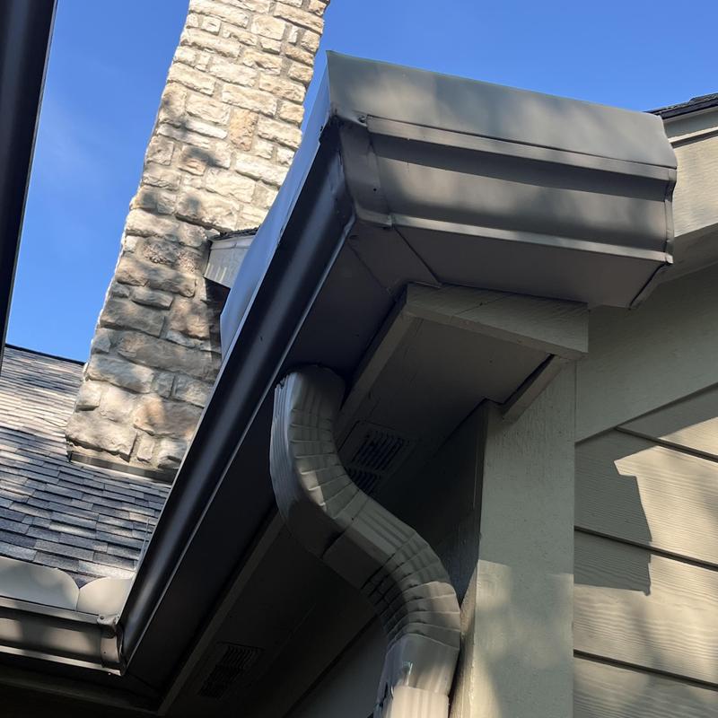 Gutter guard and downspout on house corner Gutter guard and downspout on house corner