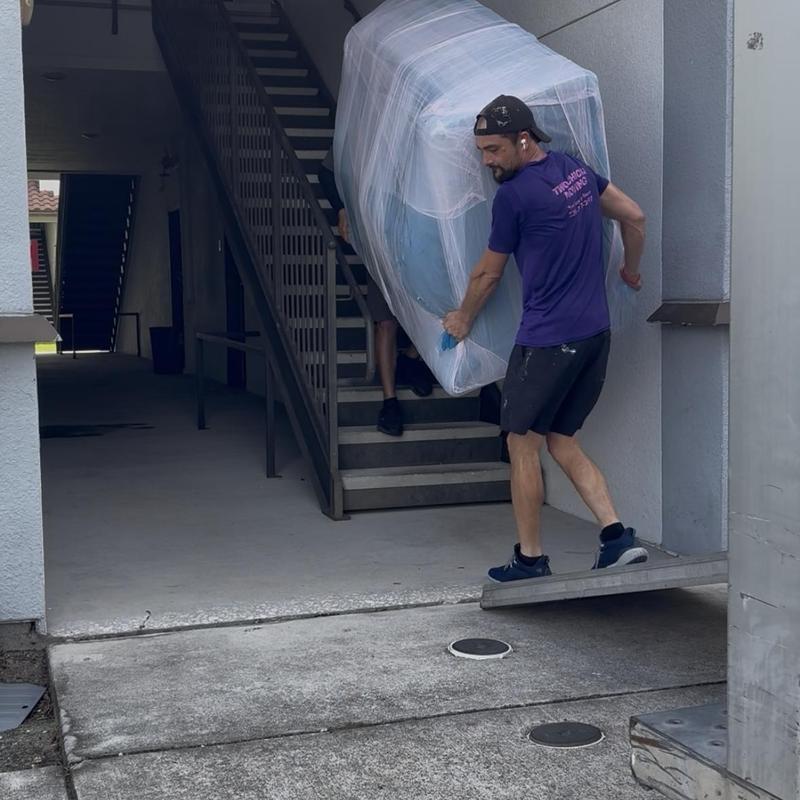 Sectional sofa wrapped and carried down stairs