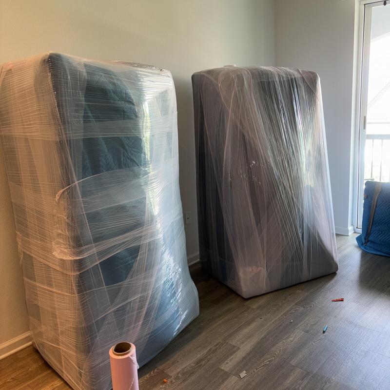 Sectional sofa wrapped in plastic for moving.