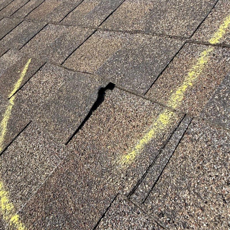 Asphalt shingles with hail damage and tear marked