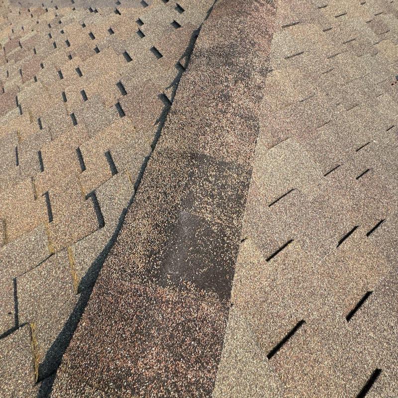 Ridge cap shingles with visible wear and damage