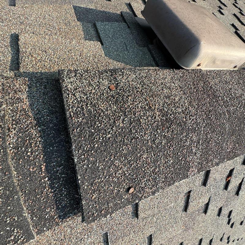 Asphalt roof shingles with visible fasteners and ventilation unit