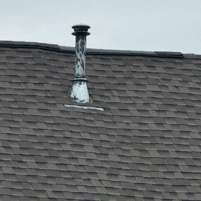 Roof flashing with hail damage on asphalt shingles
