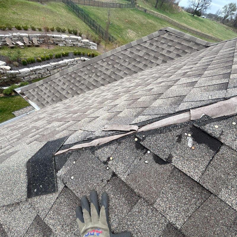 Roof shingles with hail damage near ridge flashing