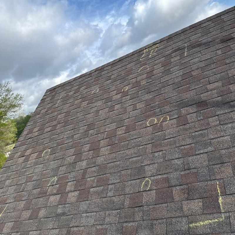 Asphalt roof shingles with hail damage markings