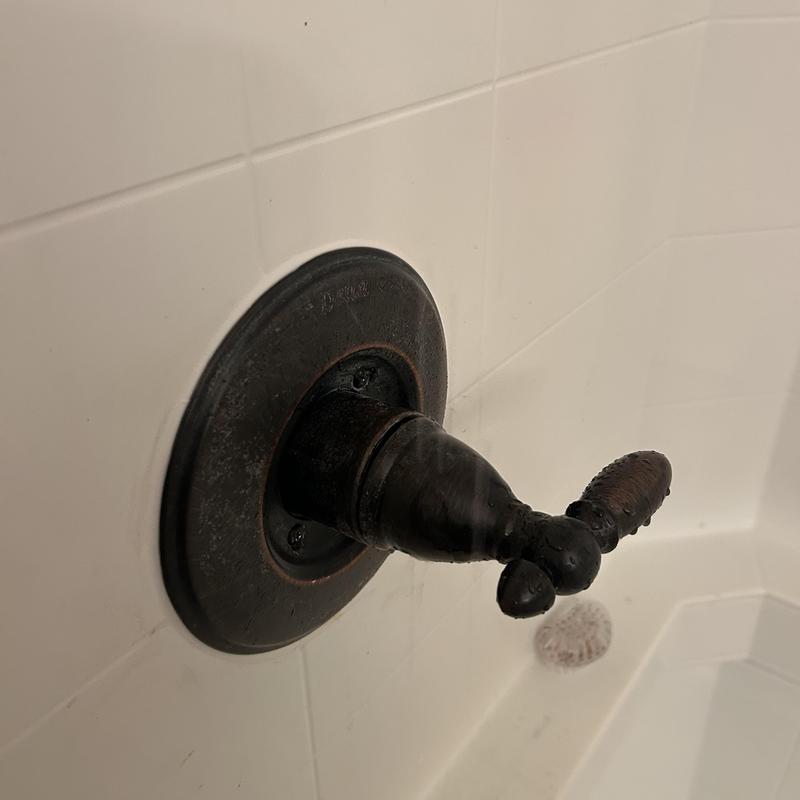 Shower valve handle on white tile wall close-up Shower valve handle on white tile wall close-up