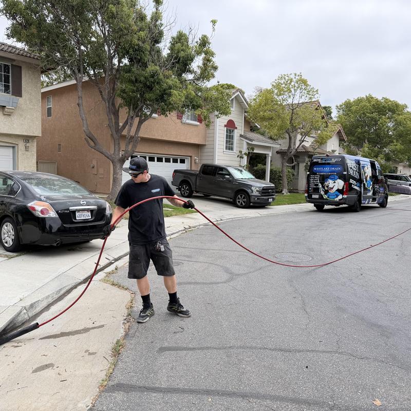 Storm drain hydro jet cleaning with technician in street