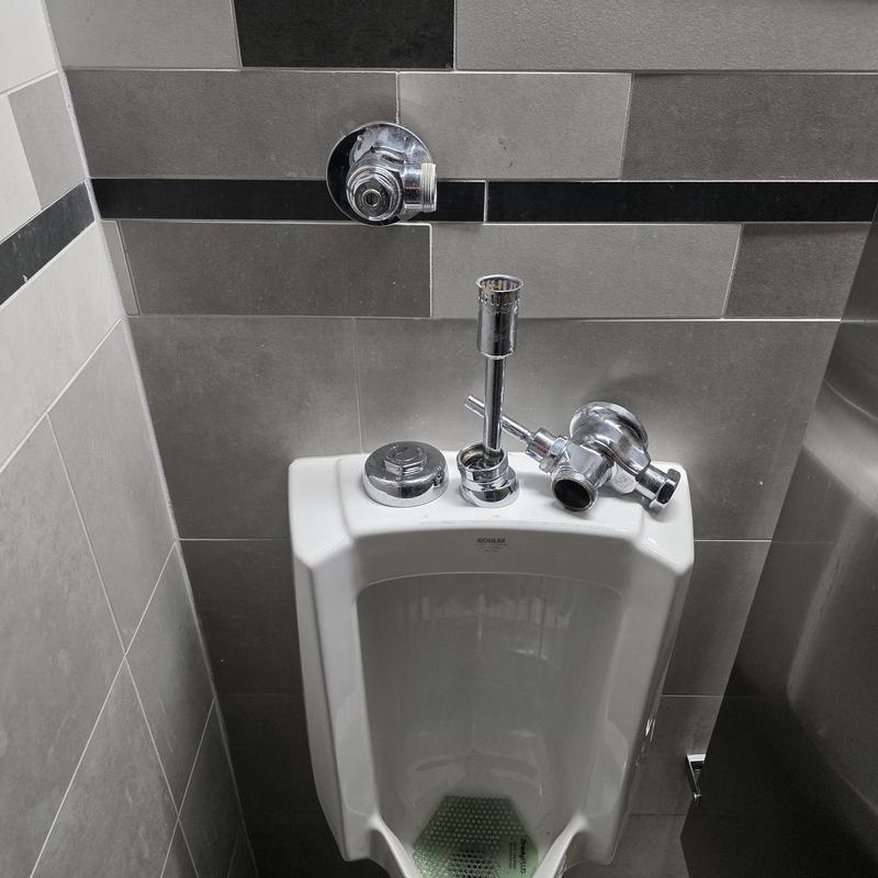Sloan flush valve and urinal installation in restroom Sloan flush valve and urinal installation in restroom