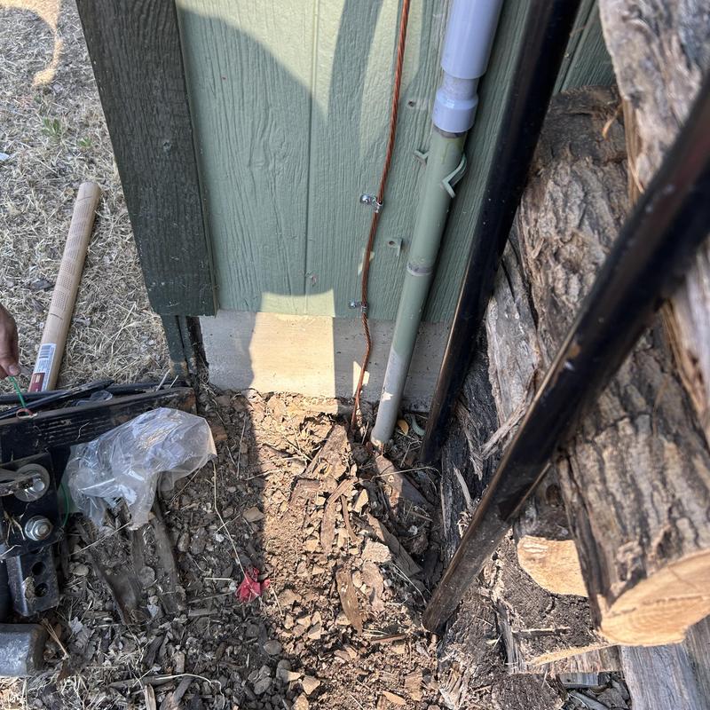 Underground electrical conduit with outdoor wiring near wall