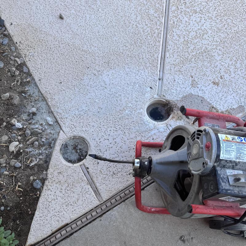 Sewer cable machine clearing drain blockage outdoors Sewer cable machine clearing drain blockage outdoors