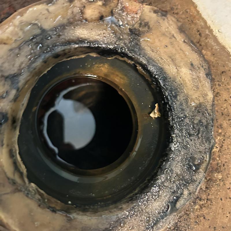 Septic tank opening with surrounding soil and residue Septic tank opening with surrounding soil and residue