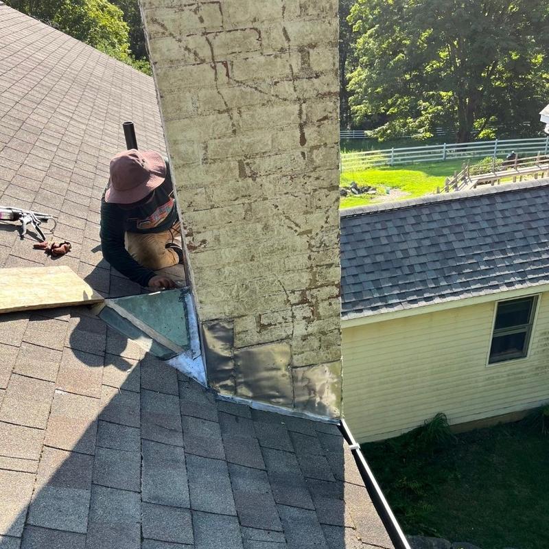 Roof chimney flashing installation on asphalt shingles Roof chimney flashing installation on asphalt shingles