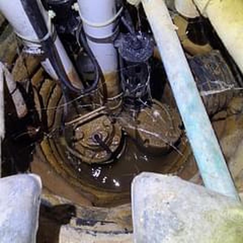 Sump pump basin with discharge pipes and wiring