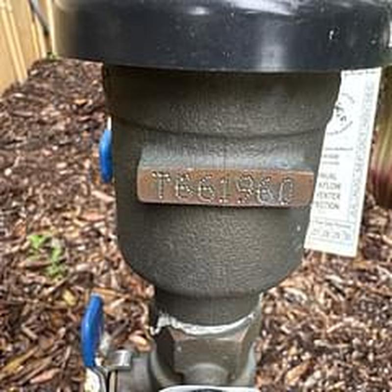 Backflow prevention device with certification tag outdoors