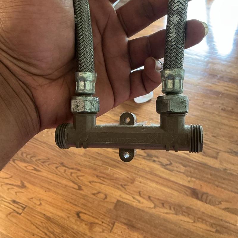 Flexible braided supply lines with plastic manifold held in hand Flexible braided supply lines with plastic manifold held in hand