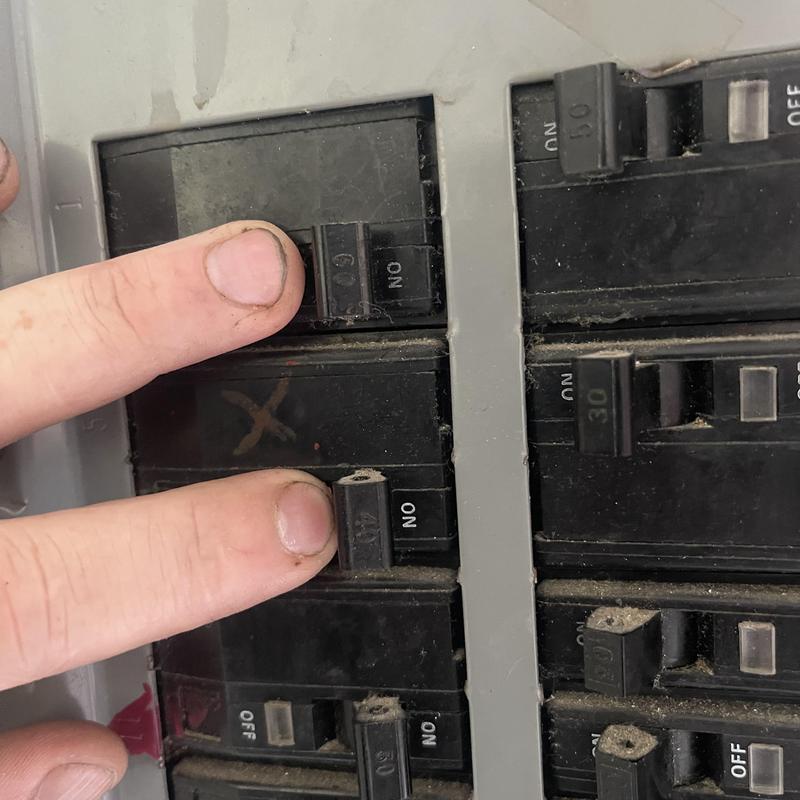 Circuit breaker panel with technician checking switches