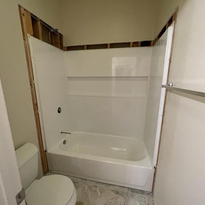 Bathtub with three-piece shower wall set installation