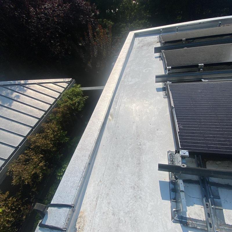Flat roof with solar panel mounts and metal roof edge