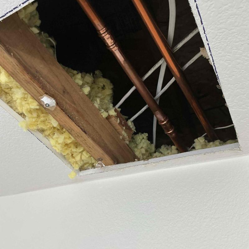 Copper pipe section with ceiling insulation exposed