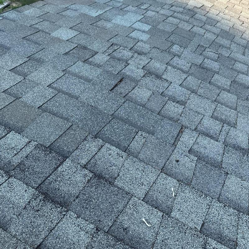 Asphalt shingle roof surface showing wear and granule loss