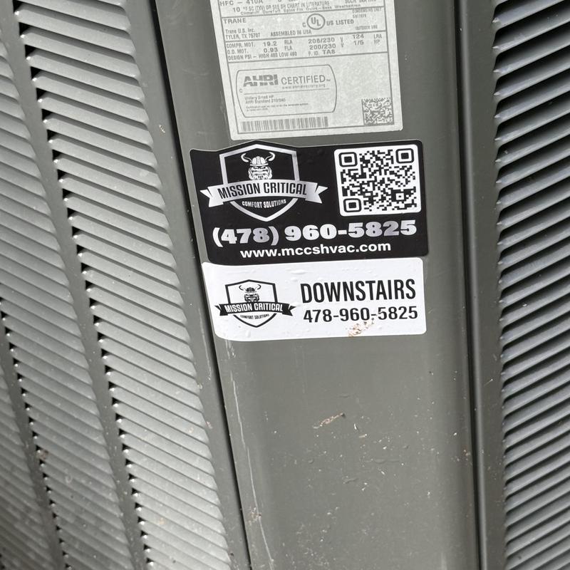 HVAC unit exterior with service company stickers HVAC unit exterior with service company stickers