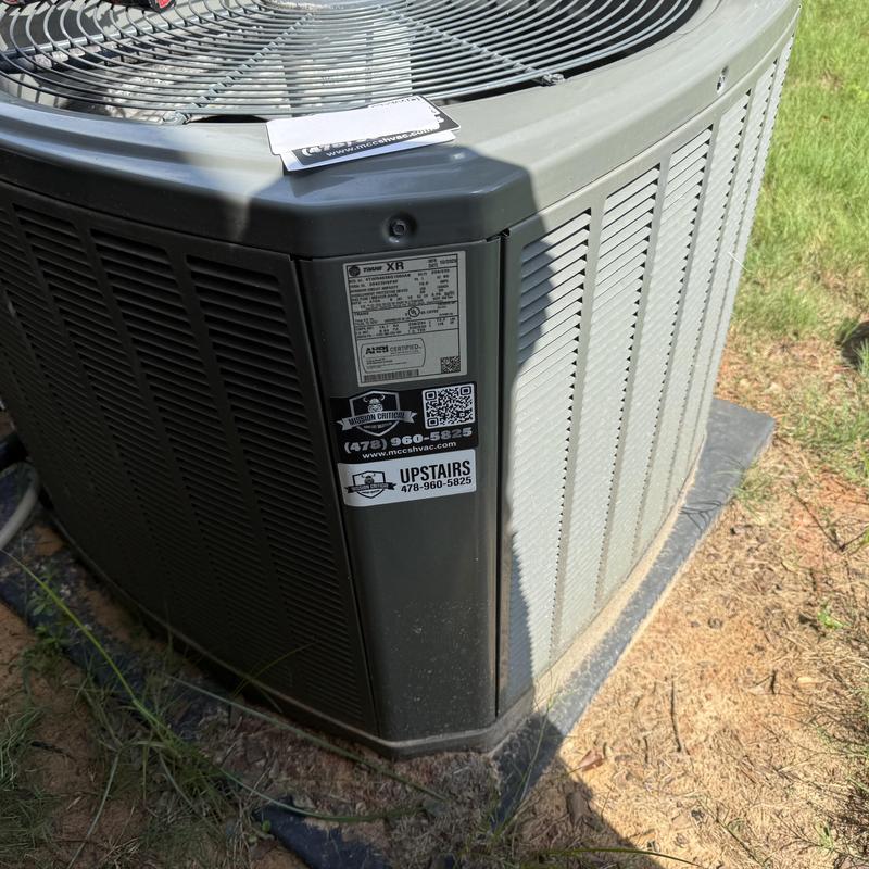 Air conditioner condenser unit with service stickers outdoors Air conditioner condenser unit with service stickers outdoors
