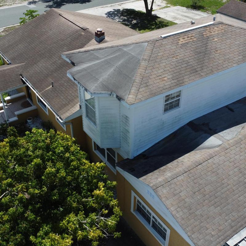 Shingle roof with damaged sections on residential house