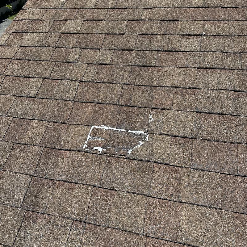 Shingle roof with damaged and patched shingles