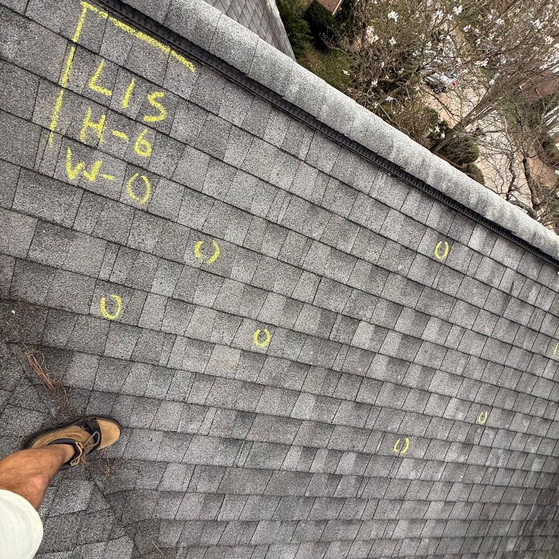 Asphalt shingles with hail damage marked in yellow chalk