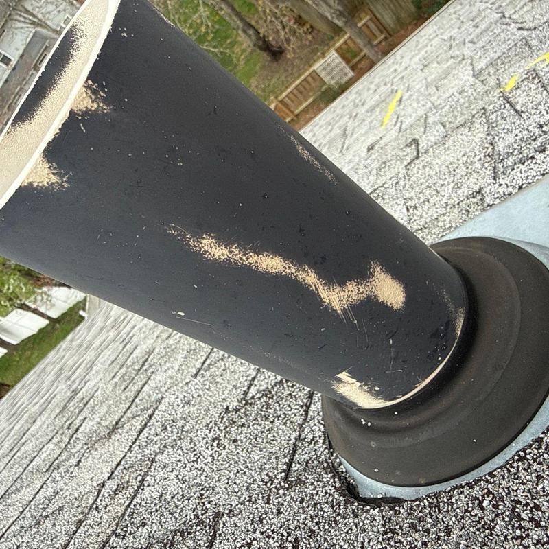 Roof vent pipe with hail damage on shingles and flashing