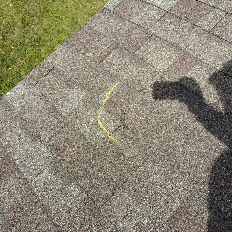 Roof shingles with marked hail damage on residential roof