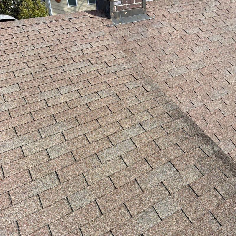 Asphalt shingle roof with hail damage near chimney flashing