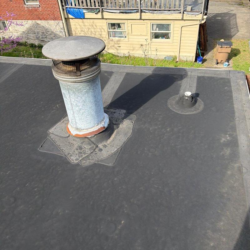 Flat roof flashing around vent pipes on residential building