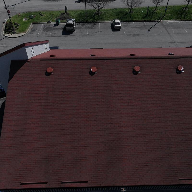 Commercial asphalt shingle roof with ventilation caps