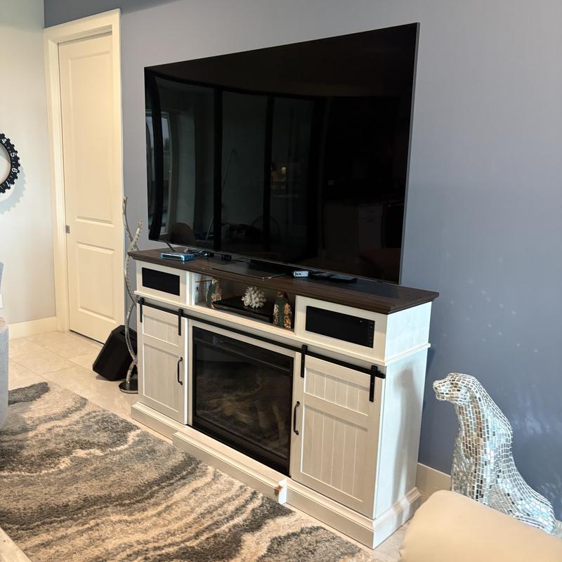 Flat-screen TV on white media console with fireplace