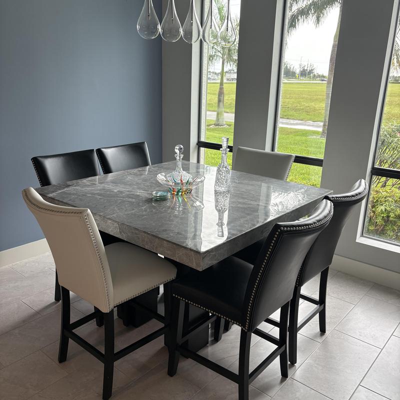 High-end granite dining table with chairs near windows