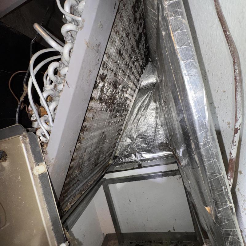 Heat pump coil with visible dirt and corrosion buildup