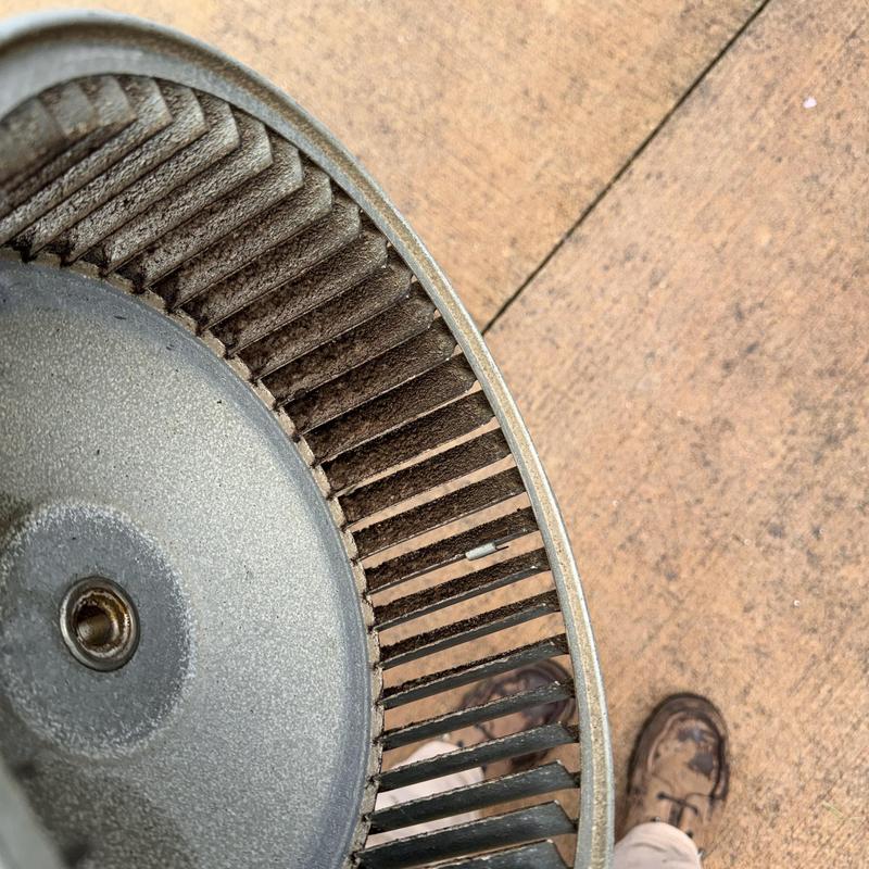 Heat pump blower wheel with worn blades on ground