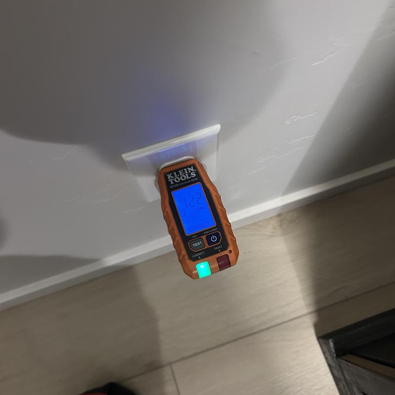 Electrical outlet tester showing voltage reading