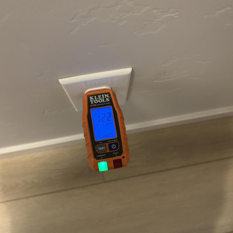 Electrical outlet voltage tester reading 122 VAC