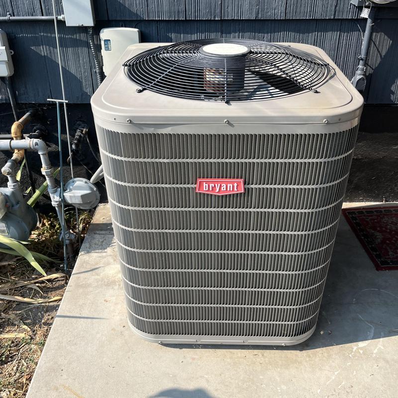 AC condenser unit on concrete pad outdoors AC condenser unit on concrete pad outdoors